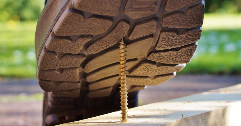 a closeup image of a shoe about to step on a nail as a representation of premises liability and the need for a personal injury attorney