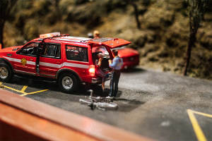 Emergency services vehicle at the scene of an accident and a person receiving medical treatment.