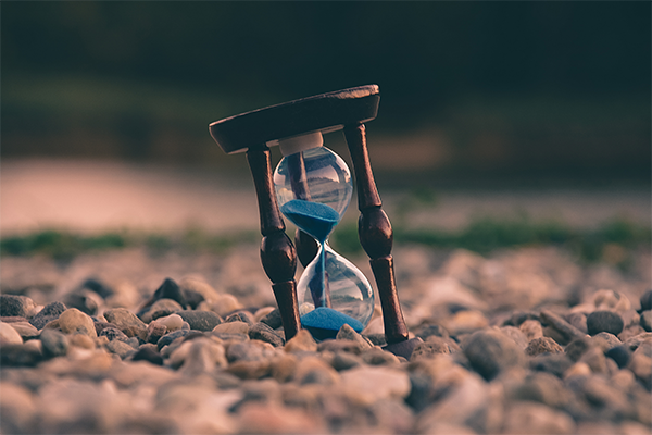 An hourglass with sand falling through, indicating the passing of time in delaying your injury claim.