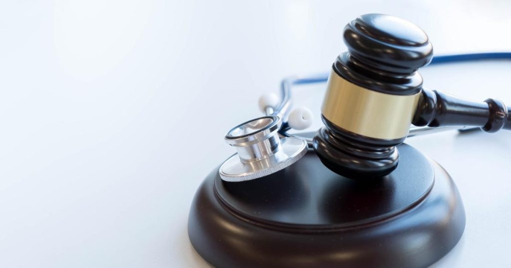 A stethoscope and gavel mallet resting on a mallet block, representing medical malpractice claim. 